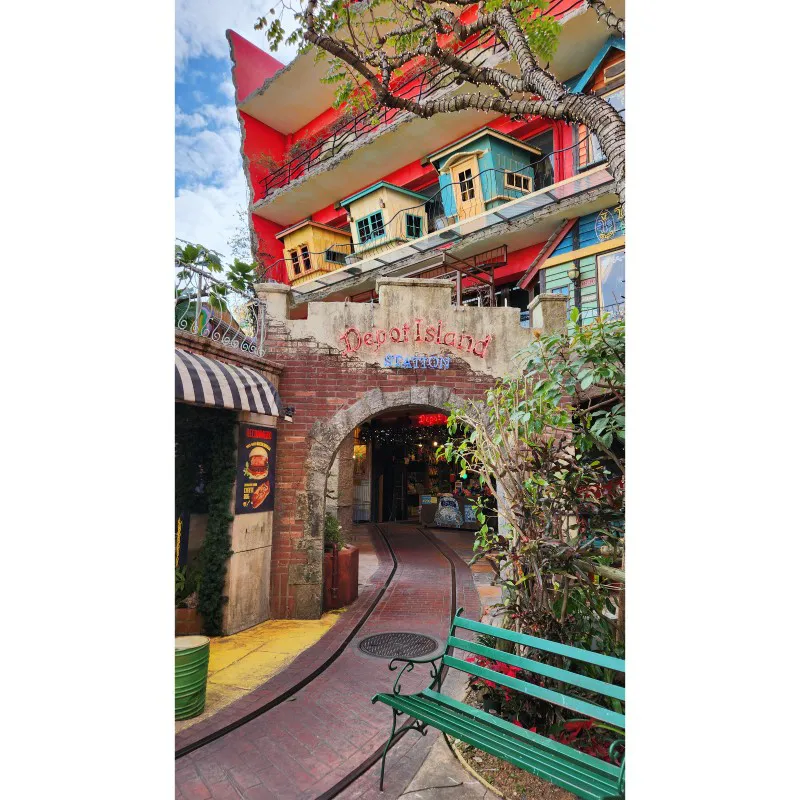 Entrada de Depot Island Station con edificios coloridos en American Village en Okinawa