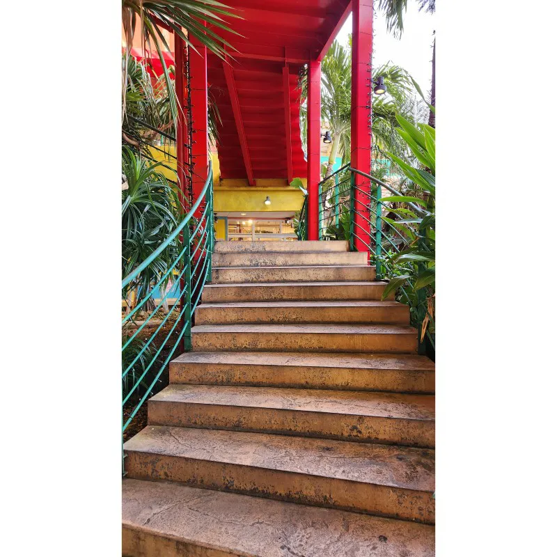 Escalera exterior rodeada de plantas tropicales en American Village en Chatan, Okinawa