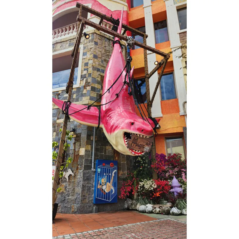 Estatua gigante de tiburón rosa colgando en el exterior de un edificio en American Village en Chatan, Okinawa
