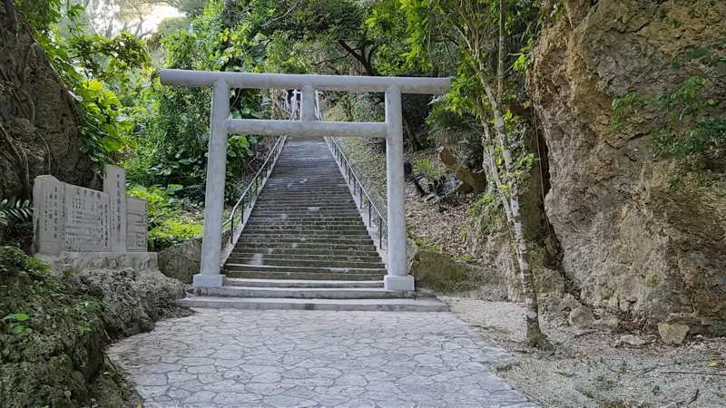 Torii y larga escalera de piedra rodeada de vegetación en Hamahigajima