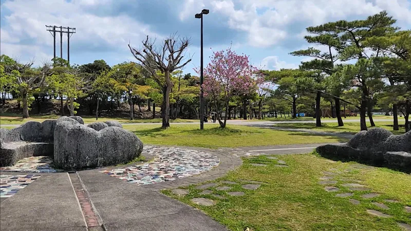 Área ajardinada con piedras y cerezos en flor en el Parque Deportivo de Kitanakagusuku Okinawa