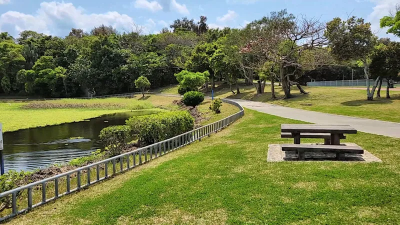 Mesa de madera junto a un estanque en el Parque Deportivo de Kitanakagusuku Okinawa